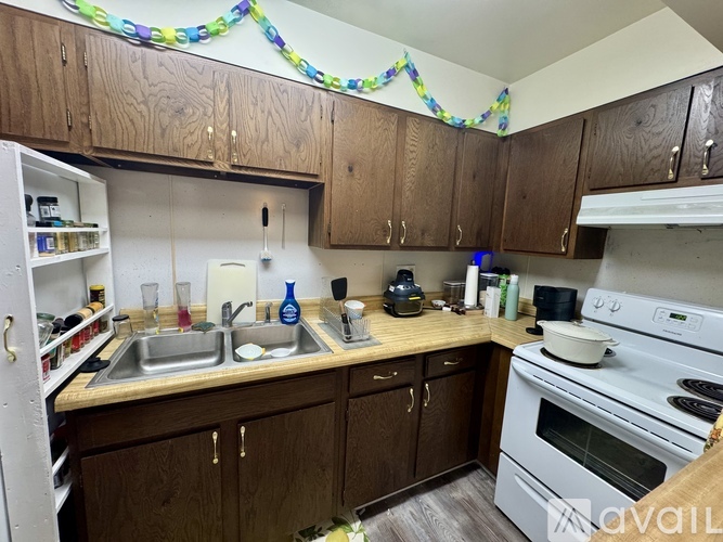 A kitchen with wooden cabinets and a white stove top oven.