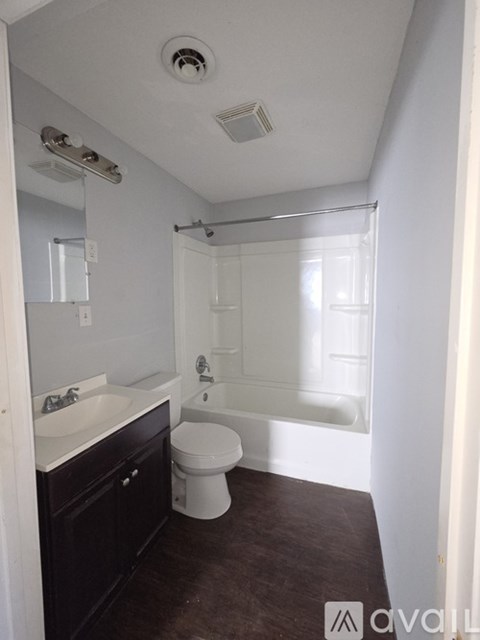 A bathroom with a toilet, sink, and bathtub.