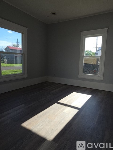 A room with a large window and a wooden floor.