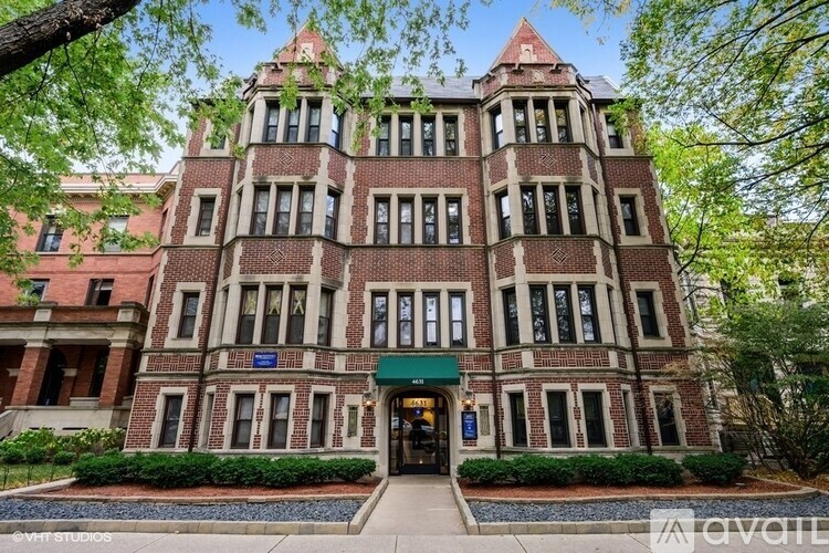 A large, red brick building with a green awning and a sign that says "available" in front of it.