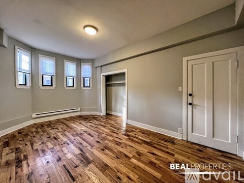 A room with wooden flooring and a white door.