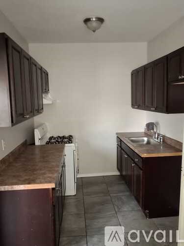 A kitchen with brown cabinets and a white fridge.