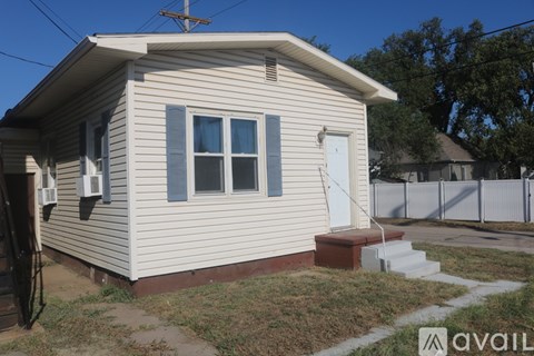 A small house with a white door and a window with a blue frame.