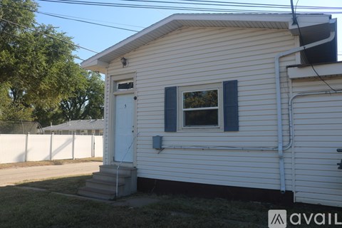 A small white house with a window and a door.