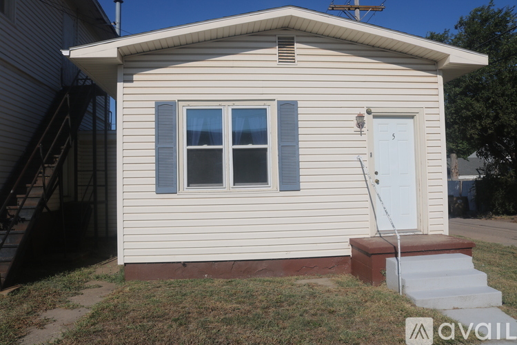 A small house with a white door and a window with a curtain.