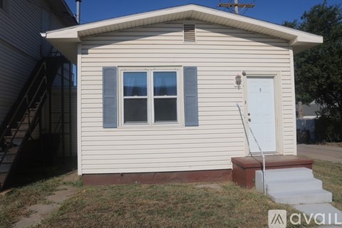 A small house with a white door and a window with a curtain.