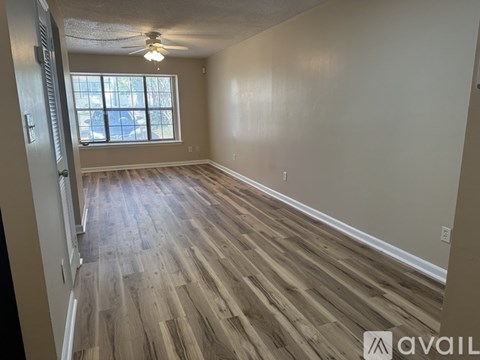 A room with wooden flooring and a window.