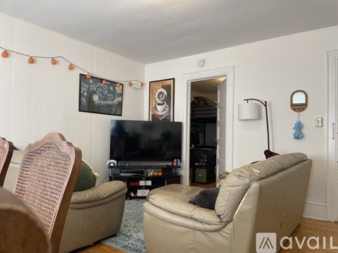 A living room with a television, two chairs, and a couch.