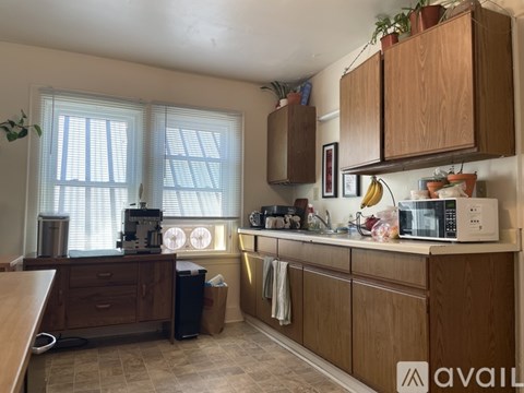 A kitchen with wooden cabinets and a microwave on the counter.