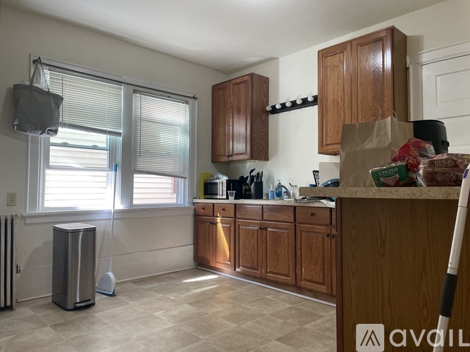 A kitchen with wooden cabinets and a tiled floor.