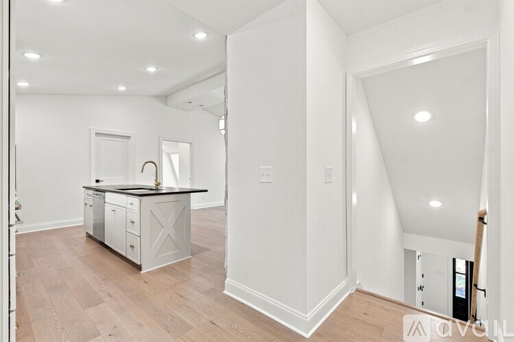 A kitchen with white cabinets and a black countertop.