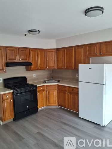 A kitchen with wooden cabinets and a white refrigerator.