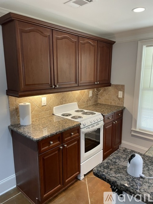 A kitchen with brown cabinets and a white stove top oven.