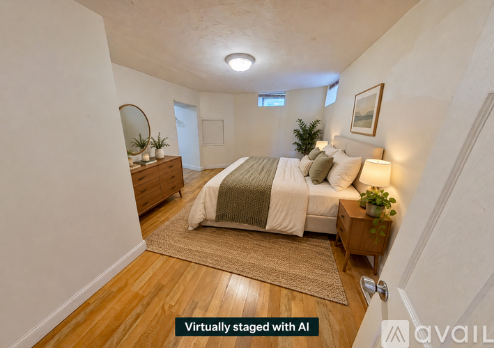 A bedroom with a bed, nightstand, and a mirror.