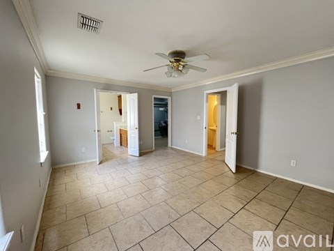 A spacious room with a ceiling fan and tiled flooring.