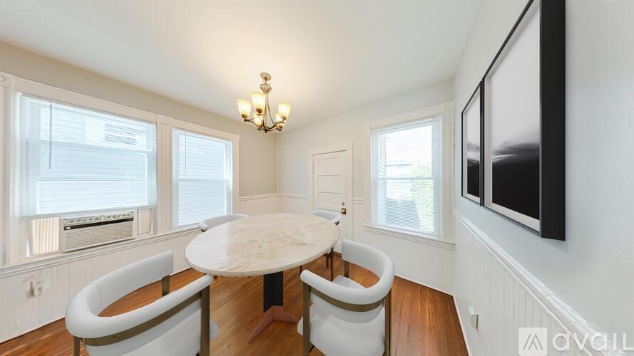 A dining room with a round table and chairs.