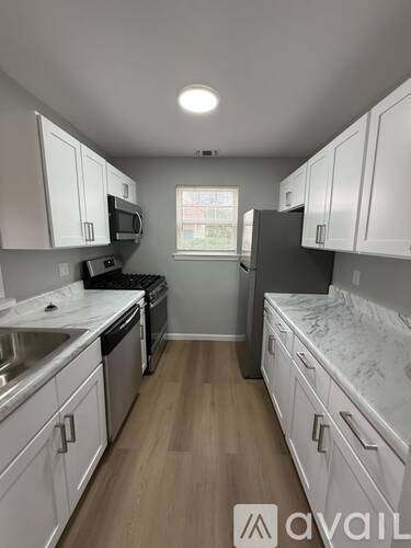 A kitchen with white cabinets and a window.