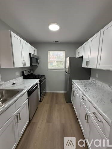 A kitchen with white cabinets and a window.