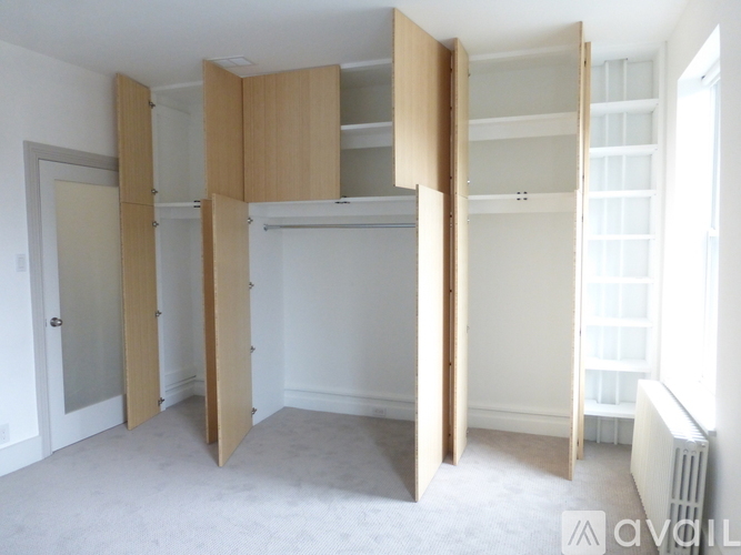 A room with a white wall and a white floor with a white radiator and a white door.
