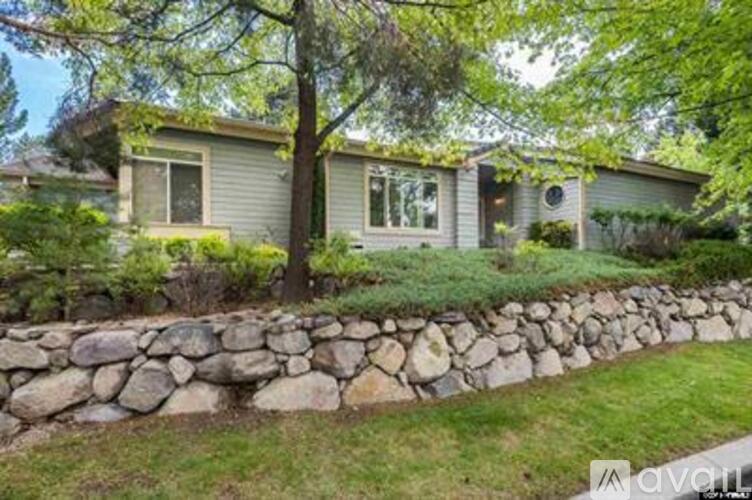 A house with a stone wall in front of it.