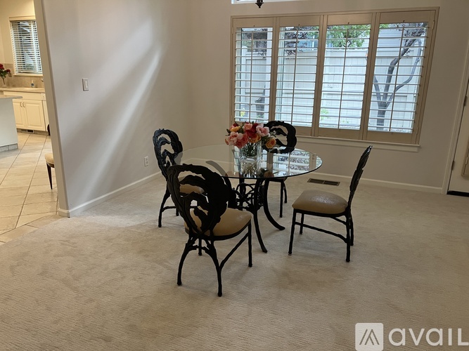 A dining room with a table set for four.