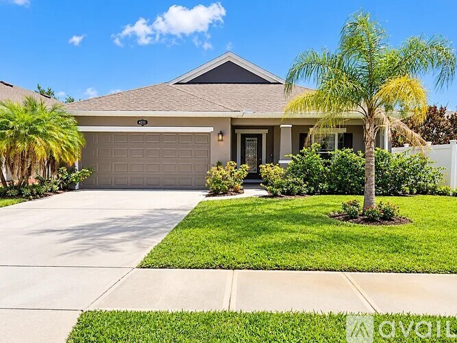 A house with a driveway and a tree in front.