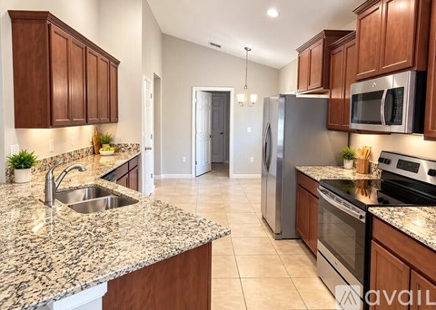 A kitchen with granite countertops and stainless steel appliances.