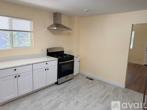 A kitchen with white cabinets and a stainless steel oven.