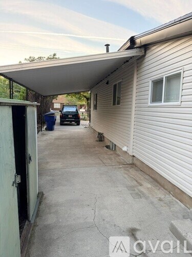 A car is parked in a driveway next to a house.