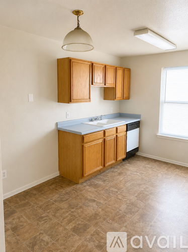 A kitchen with wooden cabinets and a tiled floor.
