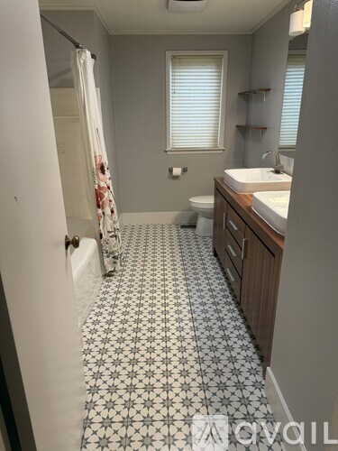 A bathroom with a white sink and a shower with a curtain.