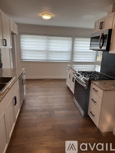 A kitchen with wooden floors and white cabinets.