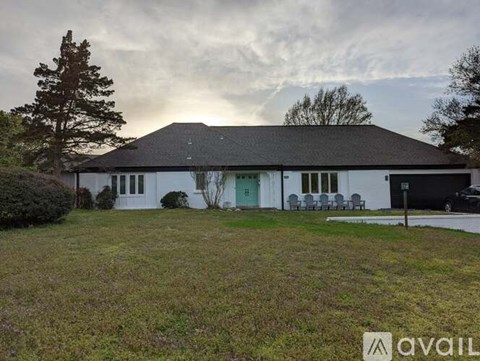 A house with a green door and a white exterior is for sale.