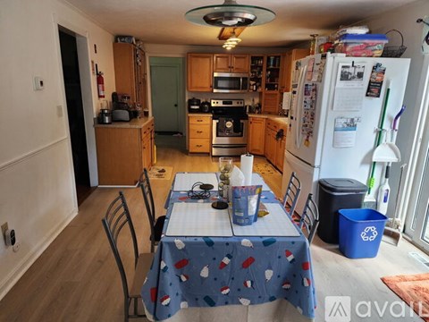 A kitchen with a table set for four with a blue tablecloth.