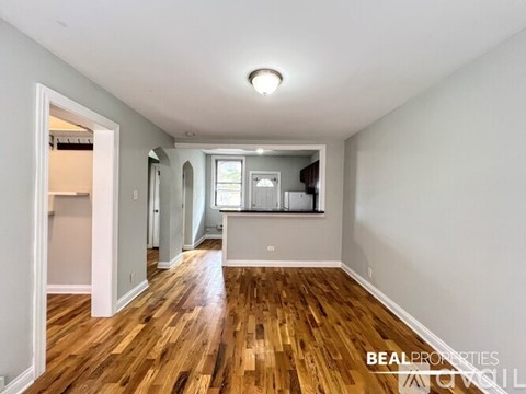 A spacious room with wooden floors and white walls.
