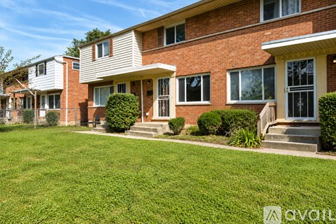 A row of houses with green lawns in front.