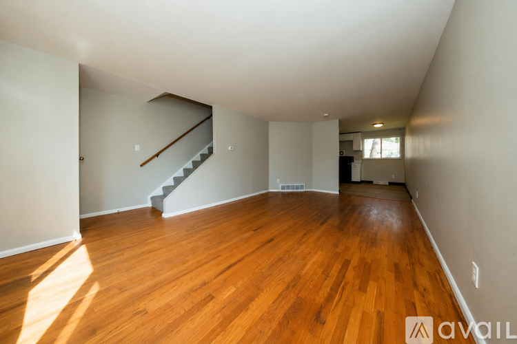 A room with wooden floors and a staircase.