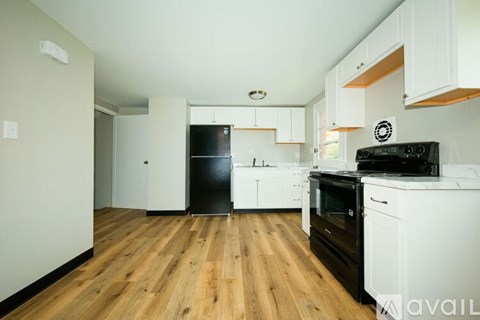 A kitchen with black appliances and white cabinets.