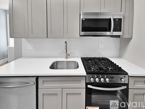 A modern kitchen with a stainless steel dishwasher and a stove top oven.