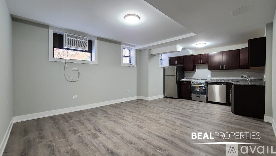 A spacious room with a kitchenette and a window.