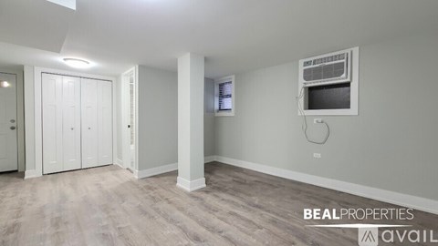 A spacious room with a wood floor and a wall-mounted television.