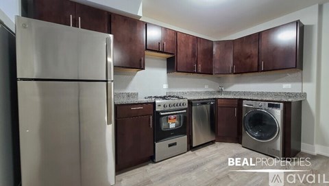A kitchen with brown cabinets and a stainless steel refrigerator.