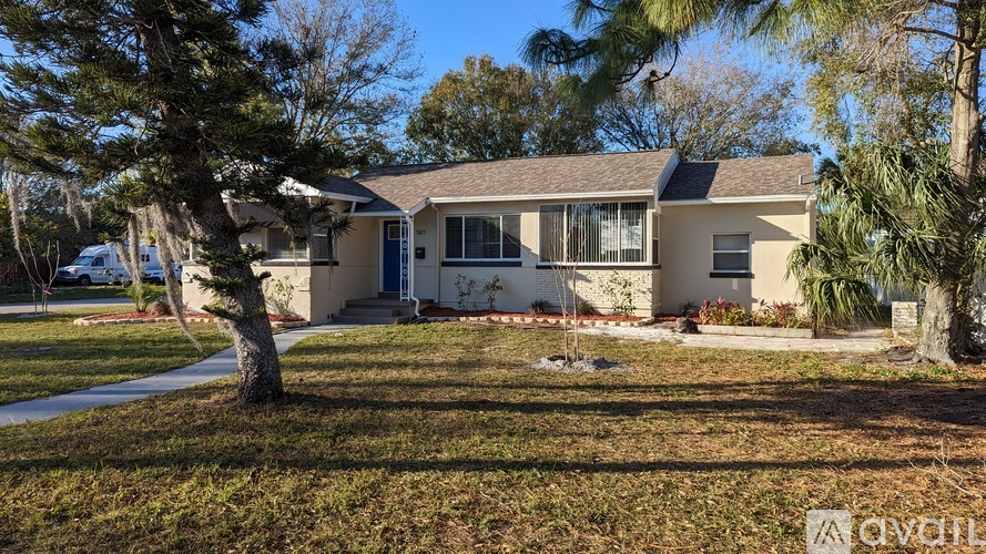 A house with a blue door and a tree in front.