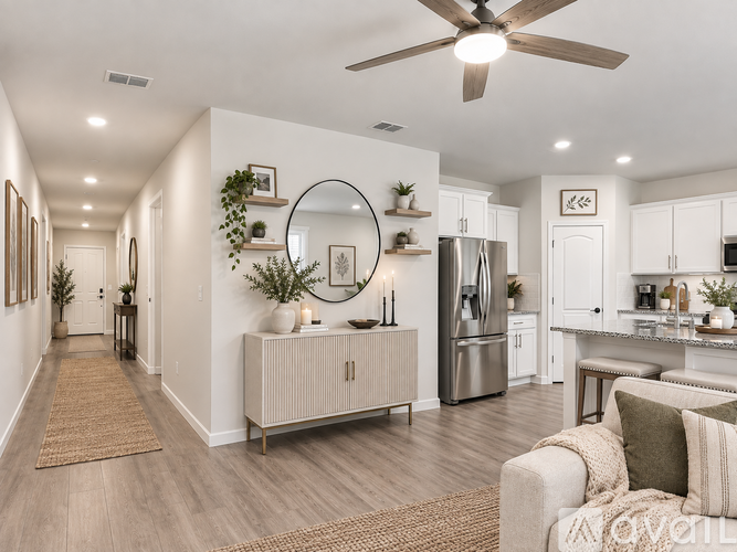 A well-lit, modern kitchen with a refrigerator, a dining table, and a couch.