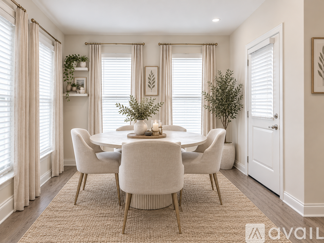 A dining room with a round table and chairs.