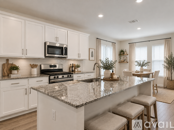 A kitchen with white cabinets and a granite countertop.