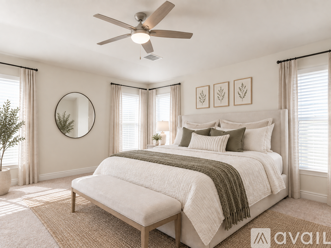 A bedroom with a large bed and a ceiling fan.