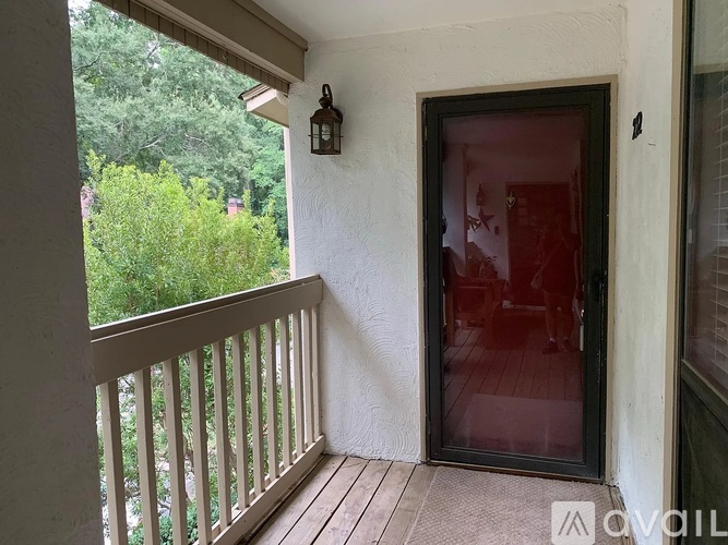 A balcony with a glass door and a lantern on the wall.