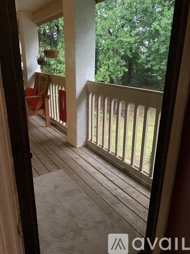 A balcony with a wooden floor and a white railing.