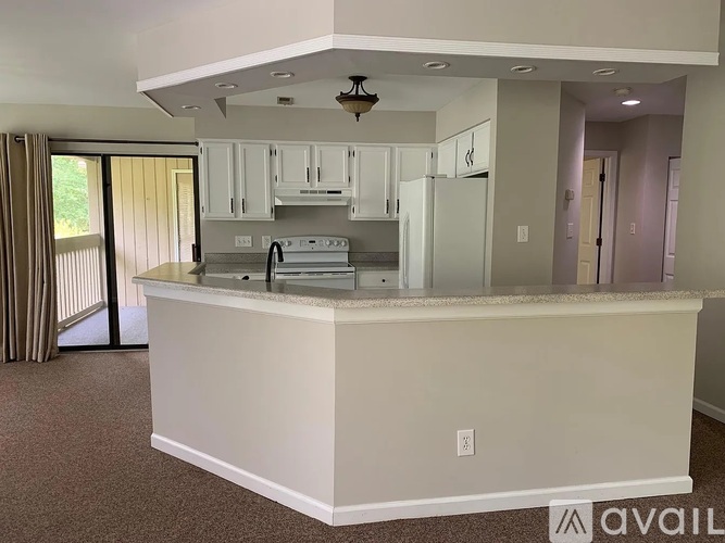 A kitchen with white cabinets and appliances is available for rent.